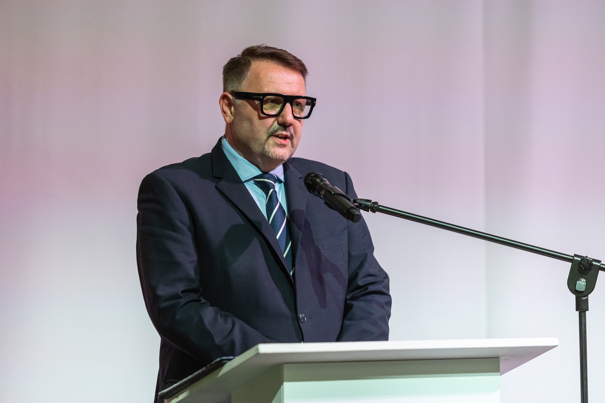 na zdjęciu osoby przemawiające ze sceny