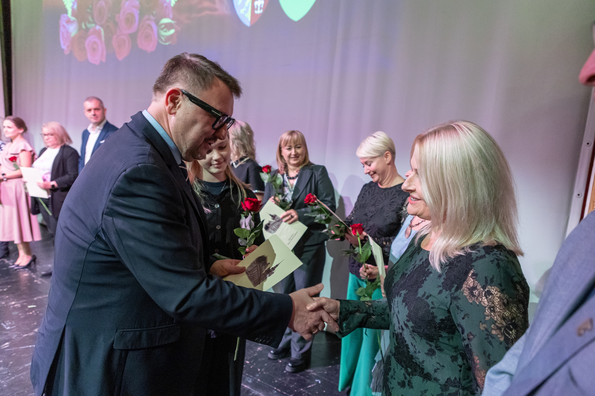 na zdjęciu osoby przemawiające ze sceny