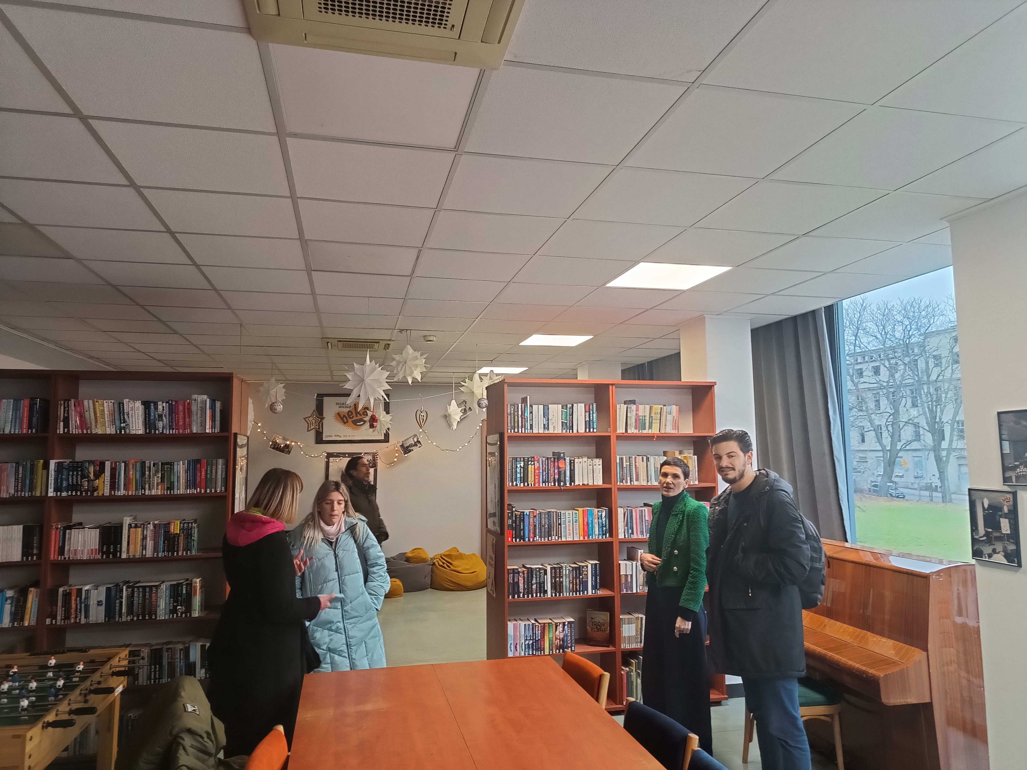 Zdjęcie przedstawiające grupę ludzi w bibliotece 