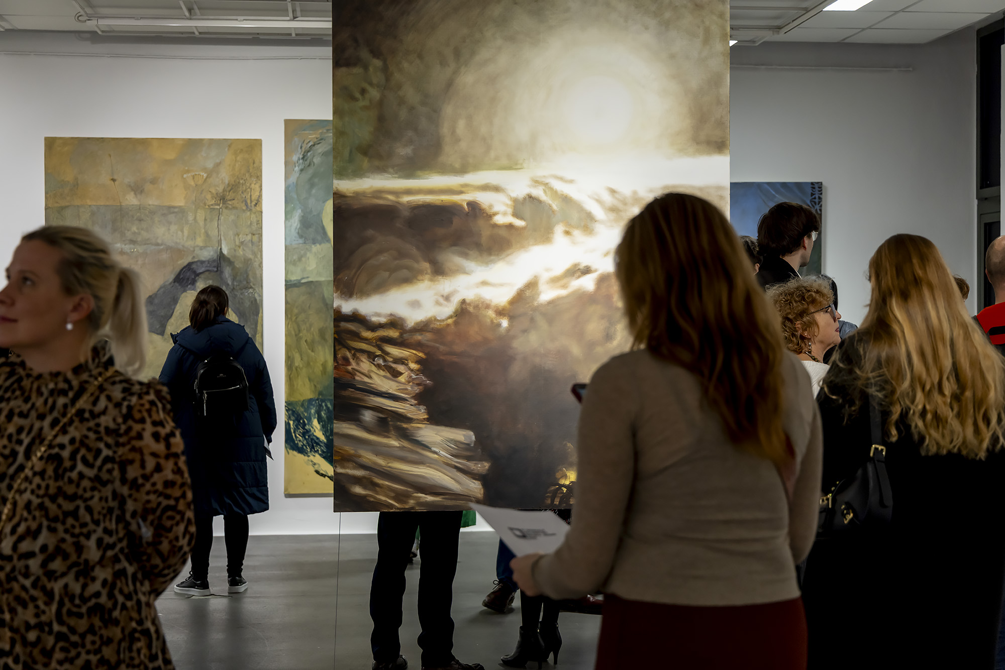 Wernisaż wystawy - osoby oglądające obrazy