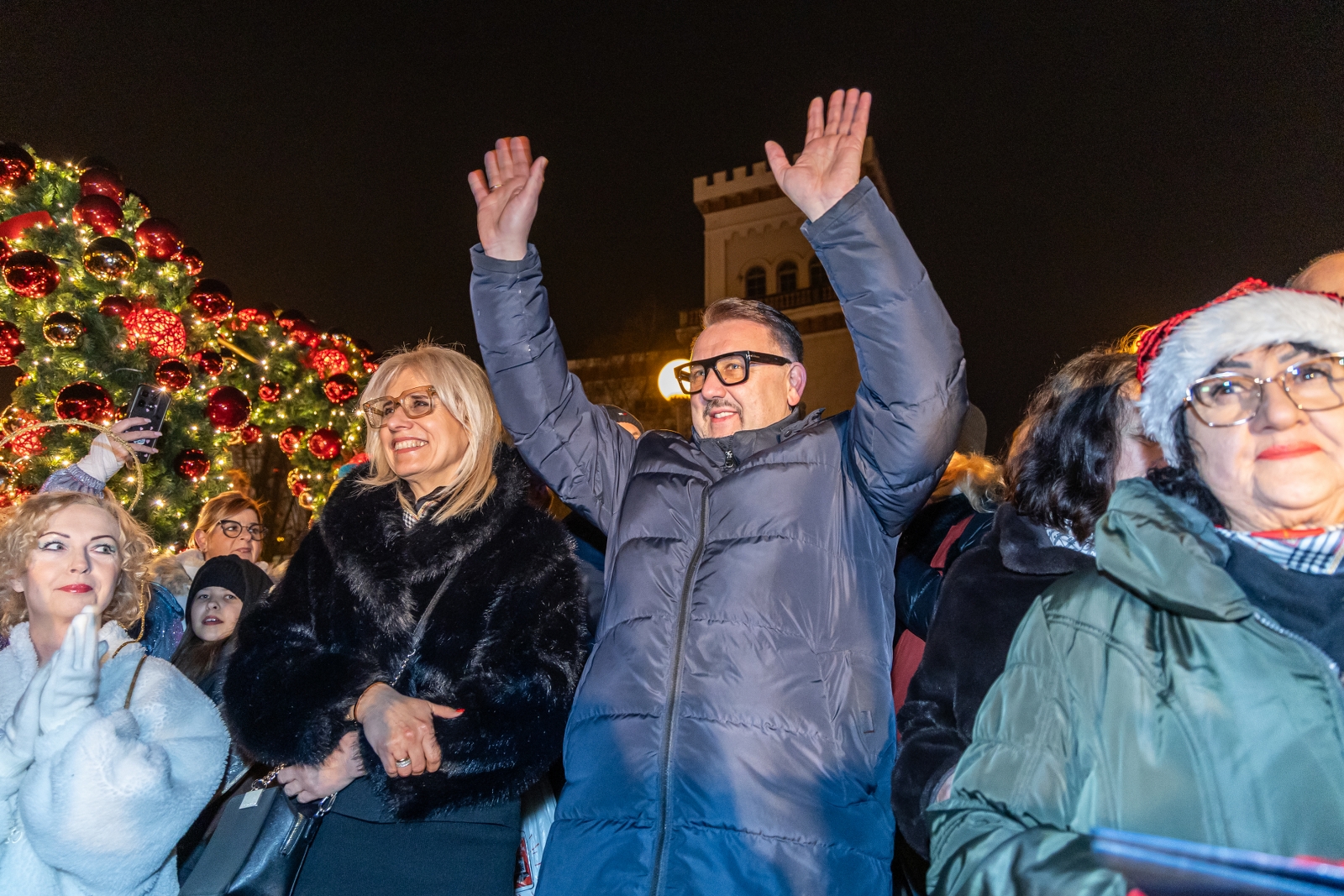 na zdjęciu ozdobione miasto i osoby podczas rozświetlenia
