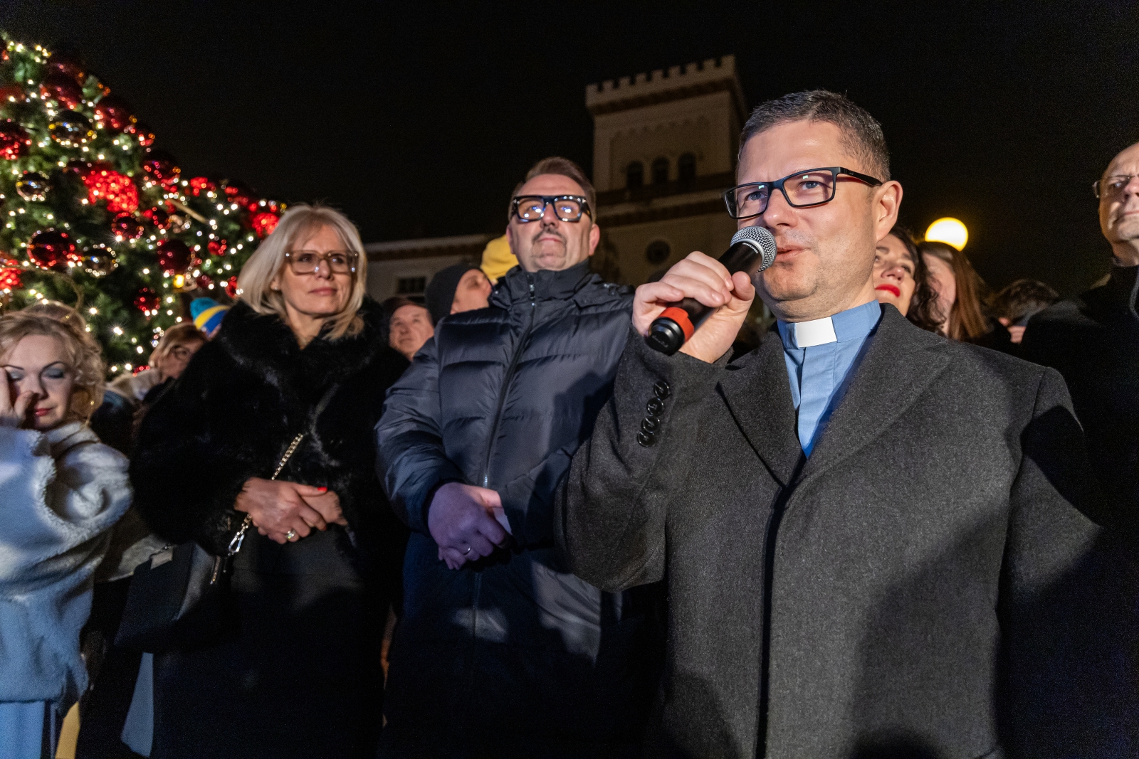 na zdjęciu ozdobione miasto i osoby podczas rozświetlenia