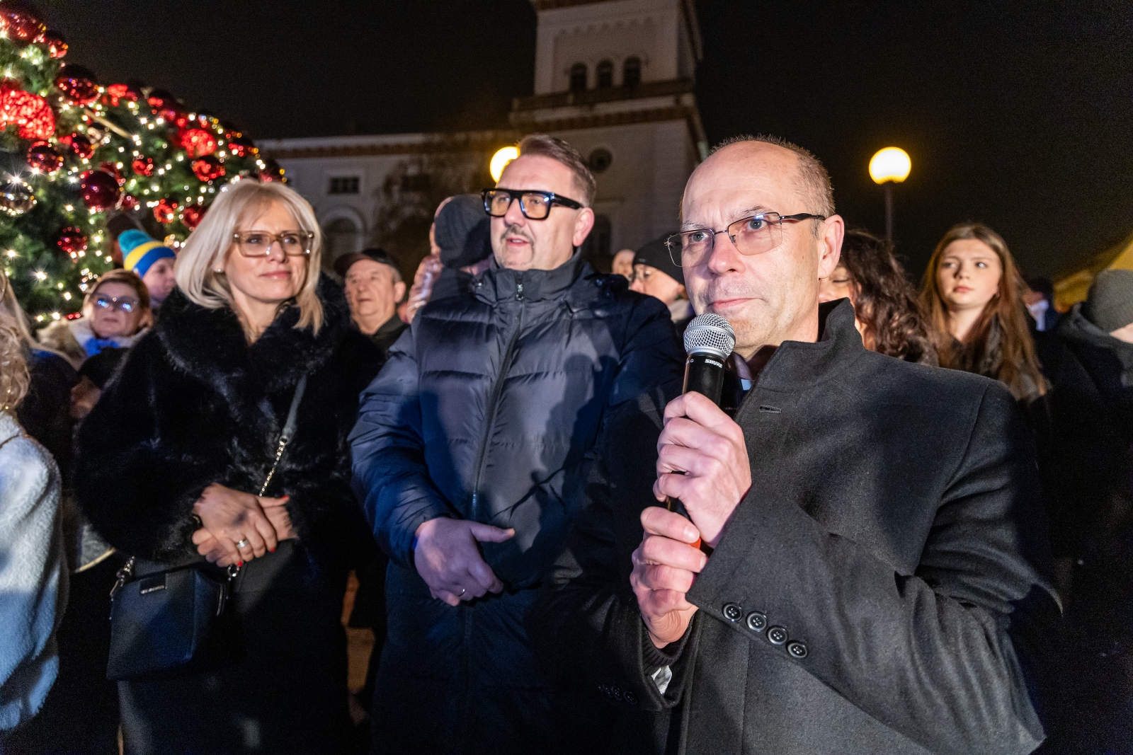 na zdjęciu ozdobione miasto i osoby podczas rozświetlenia