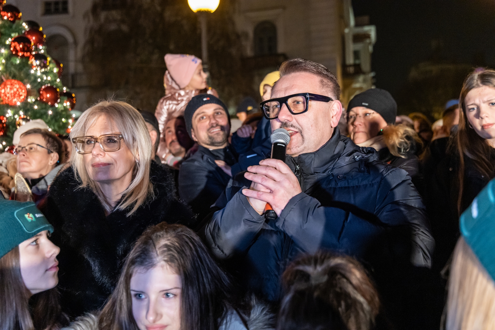 na zdjęciu ozdobione miasto i osoby podczas rozświetlenia