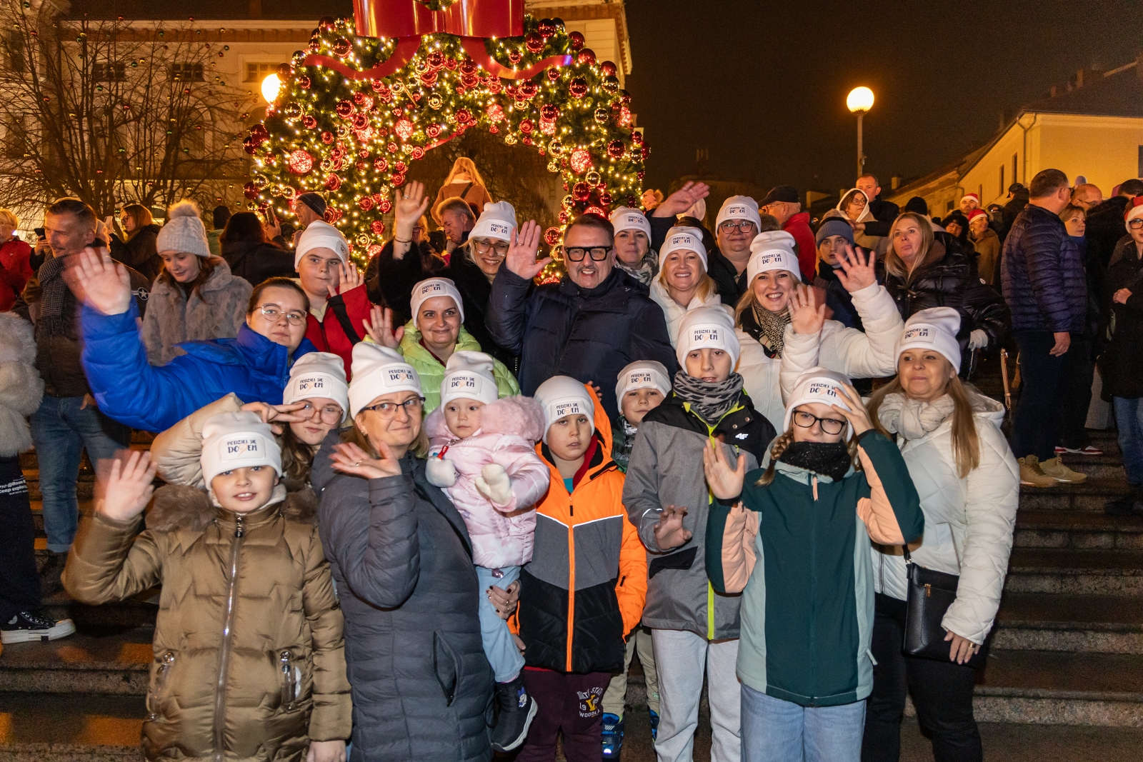 na zdjęciu ozdobione miasto i osoby podczas rozświetlenia