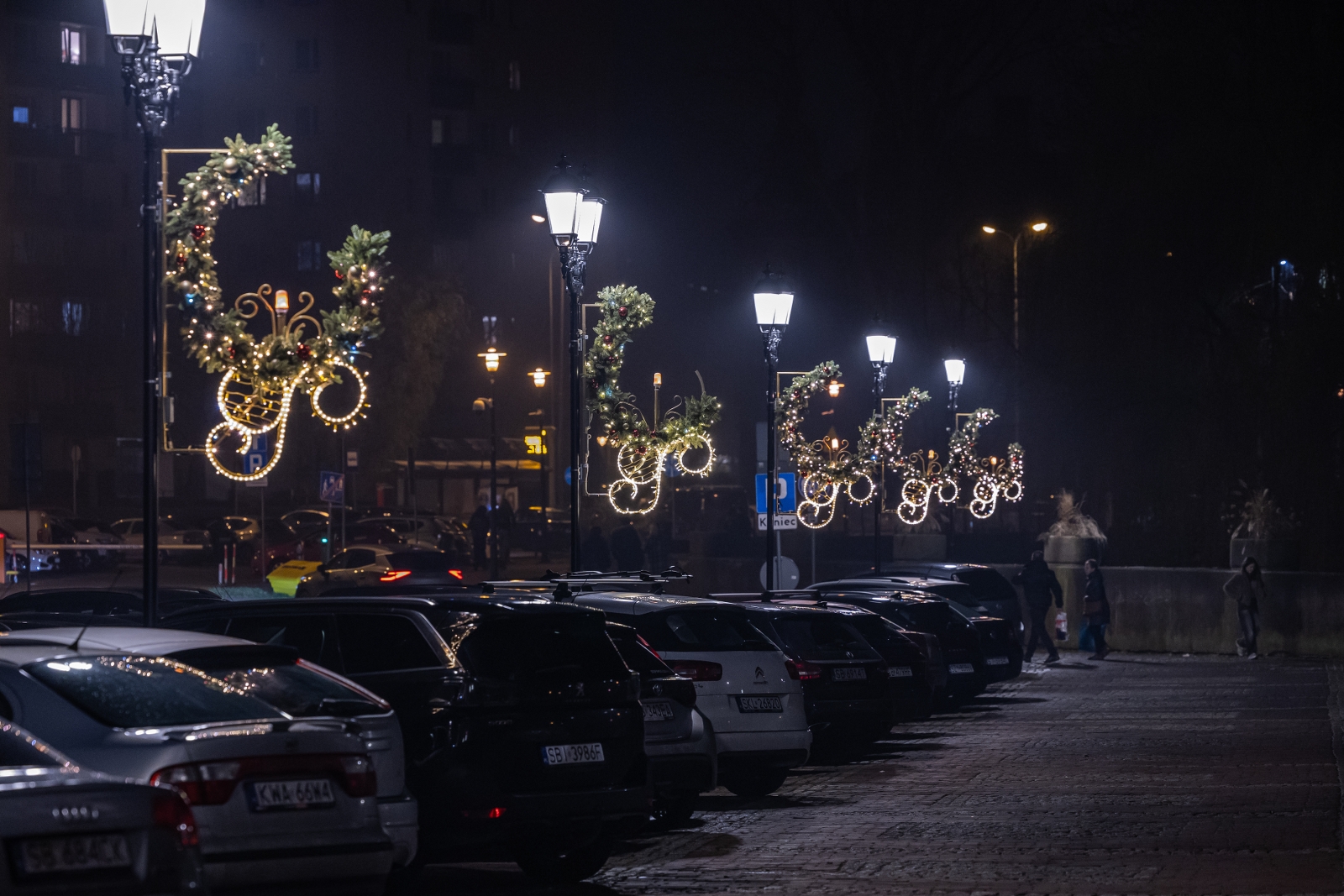 na zdjęciu ozdobione miasto i osoby podczas rozświetlenia