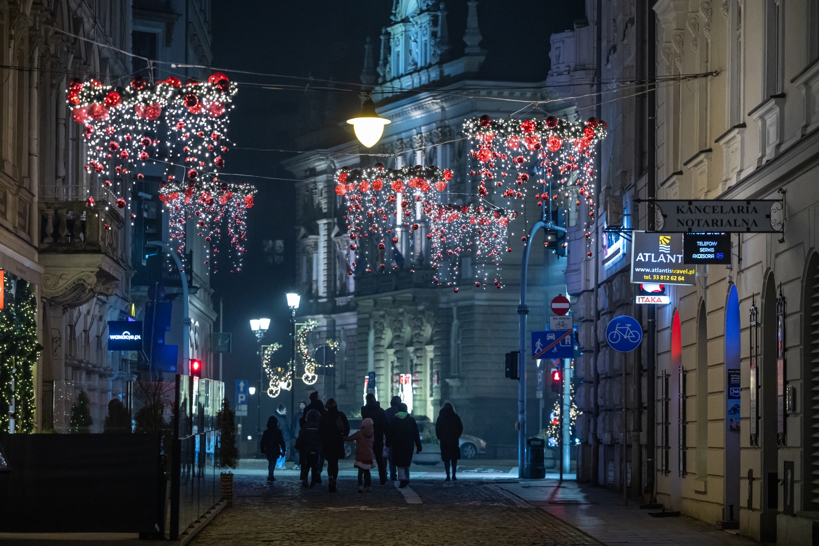na zdjęciu ozdobione miasto i osoby podczas rozświetlenia