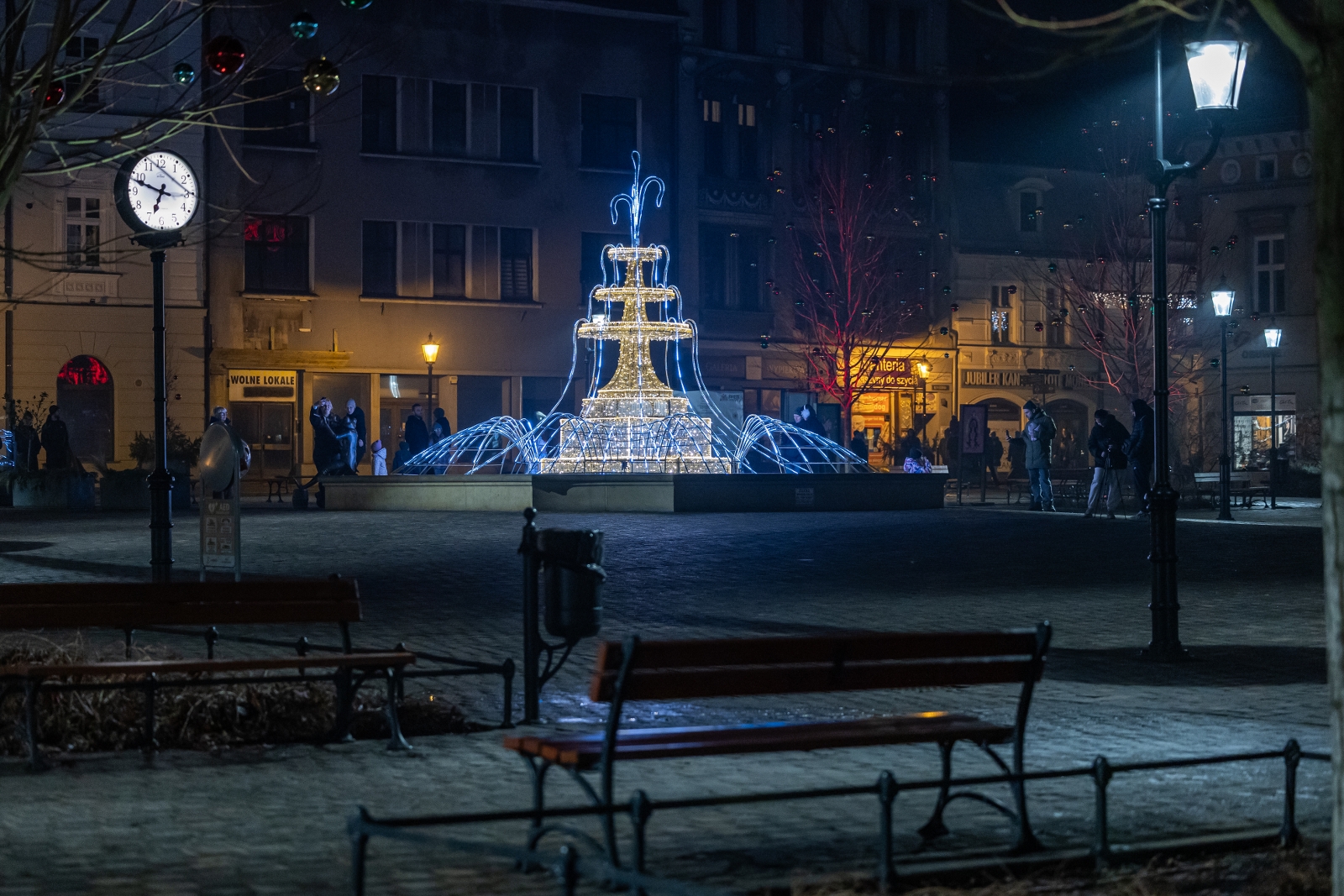 na zdjęciu ozdobione miasto i osoby podczas rozświetlenia