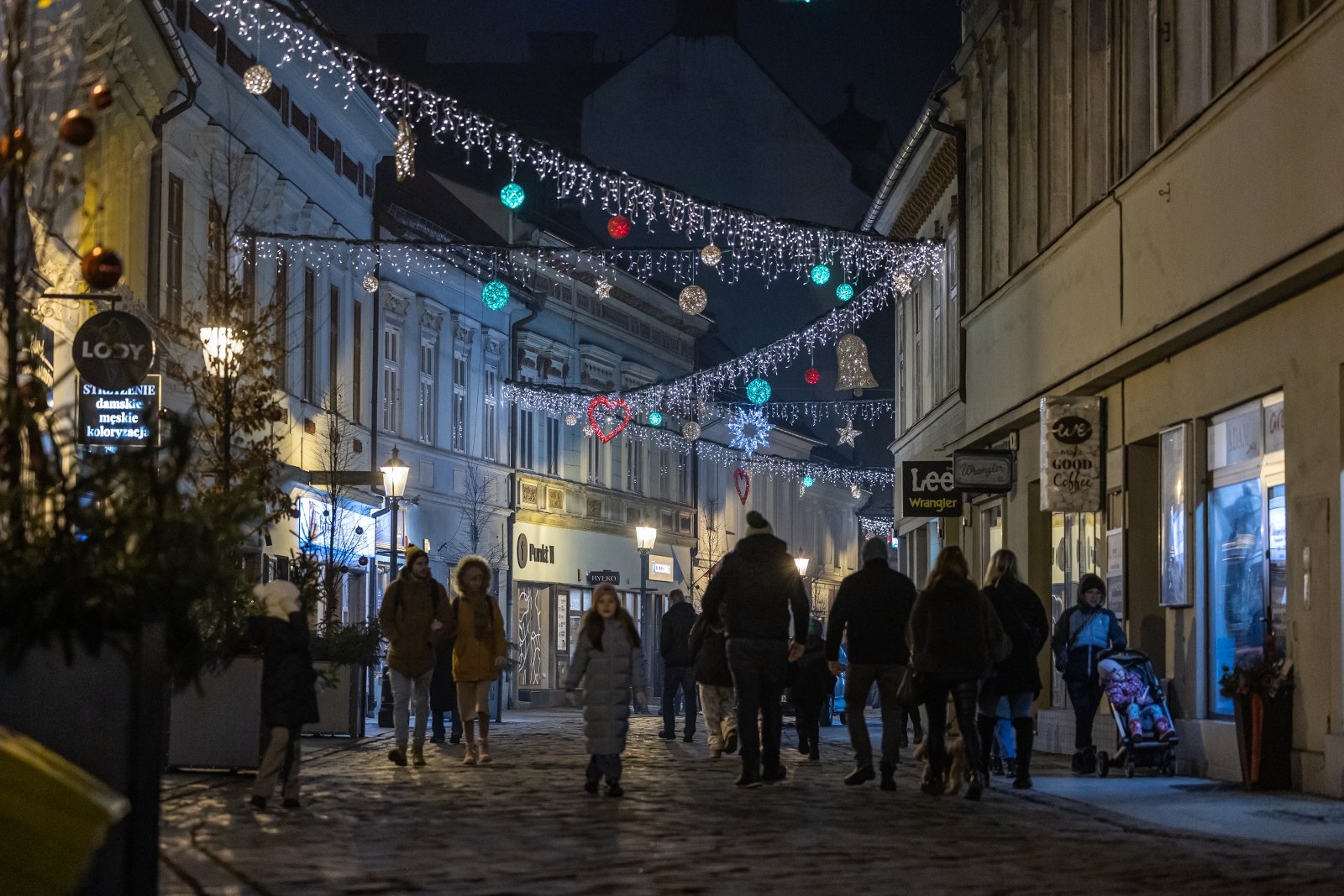 na zdjęciu ozdobione miasto i osoby podczas rozświetlenia