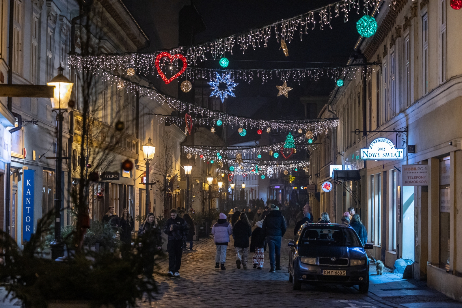 na zdjęciu ozdobione miasto i osoby podczas rozświetlenia