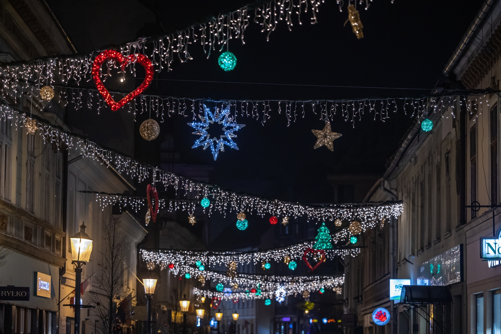 na zdjęciu ozdobione miasto i osoby podczas rozświetlenia