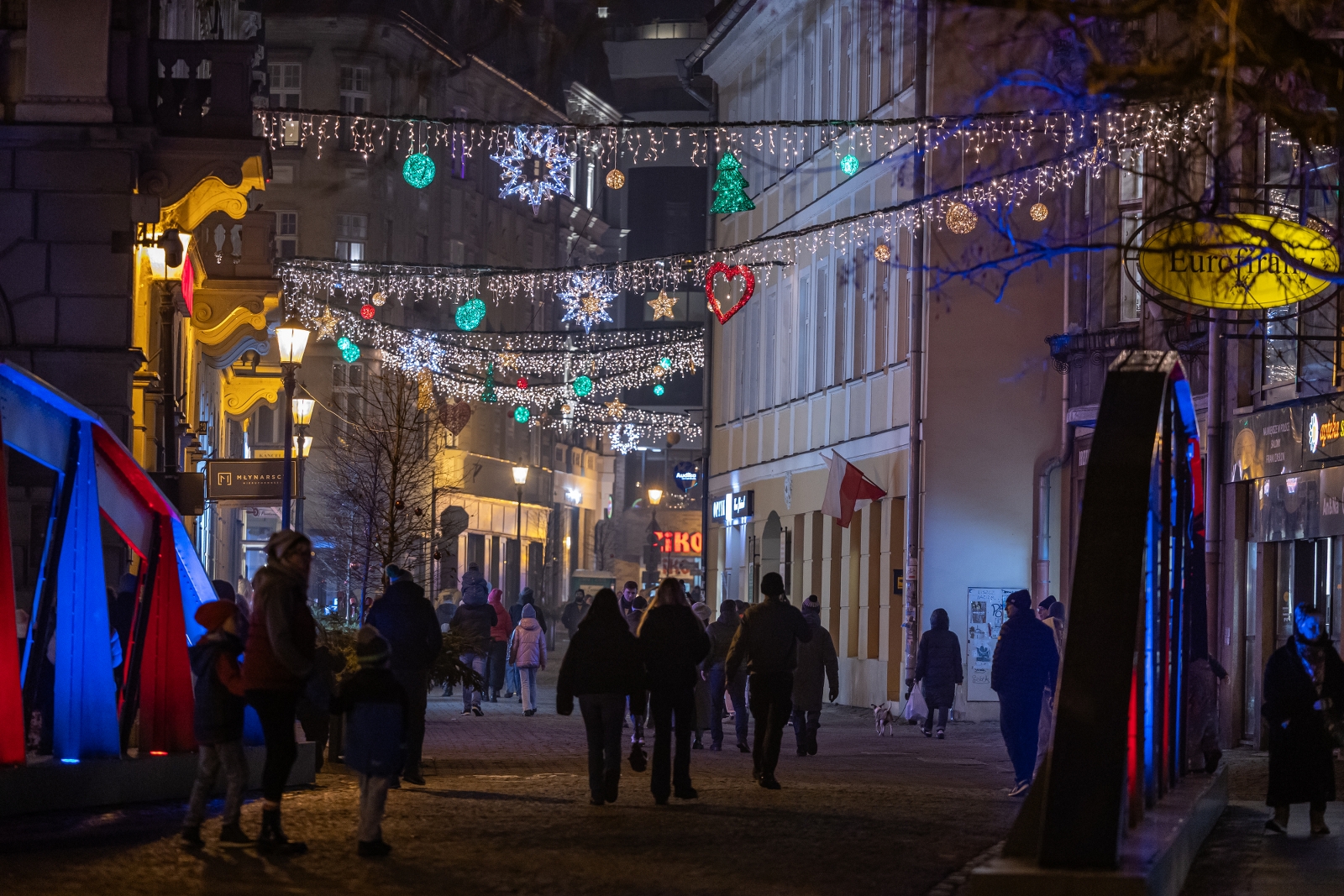 na zdjęciu ozdobione miasto i osoby podczas rozświetlenia