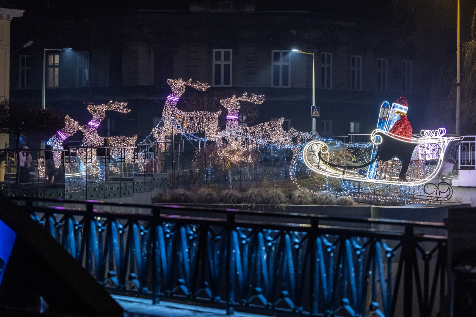 na zdjęciu ozdobione miasto i osoby podczas rozświetlenia