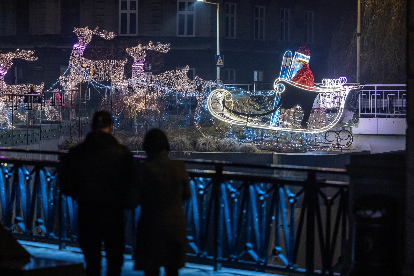 na zdjęciu ozdobione miasto i osoby podczas rozświetlenia