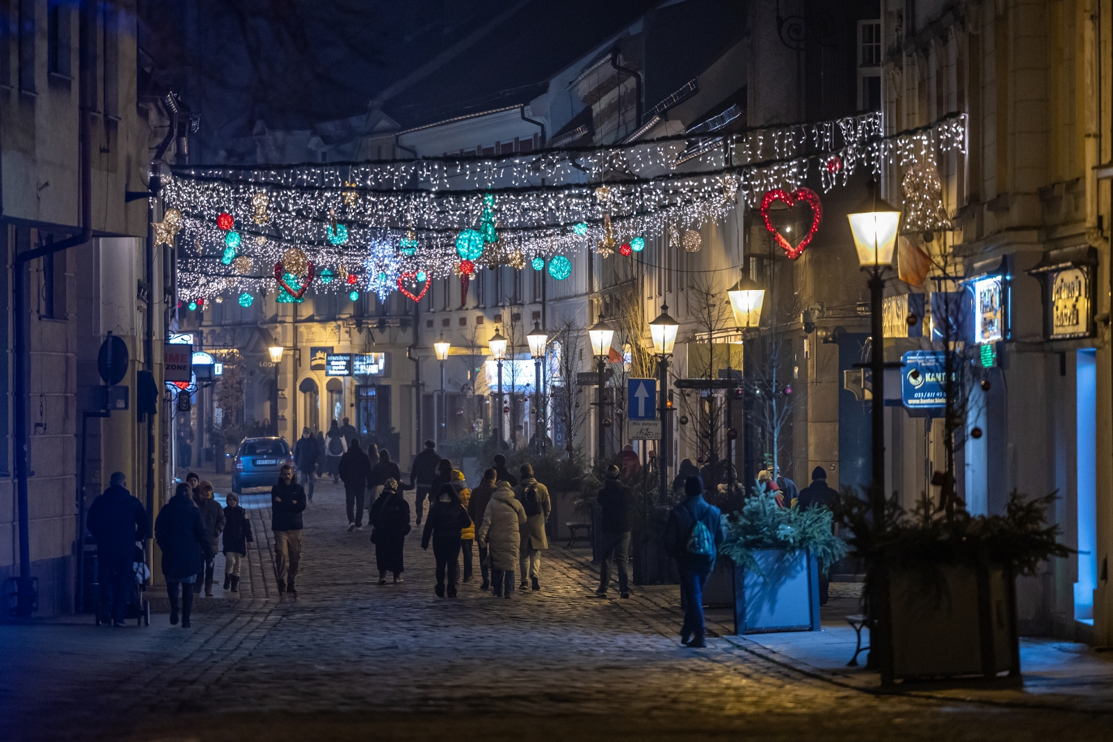 na zdjęciu ozdobione miasto i osoby podczas rozświetlenia