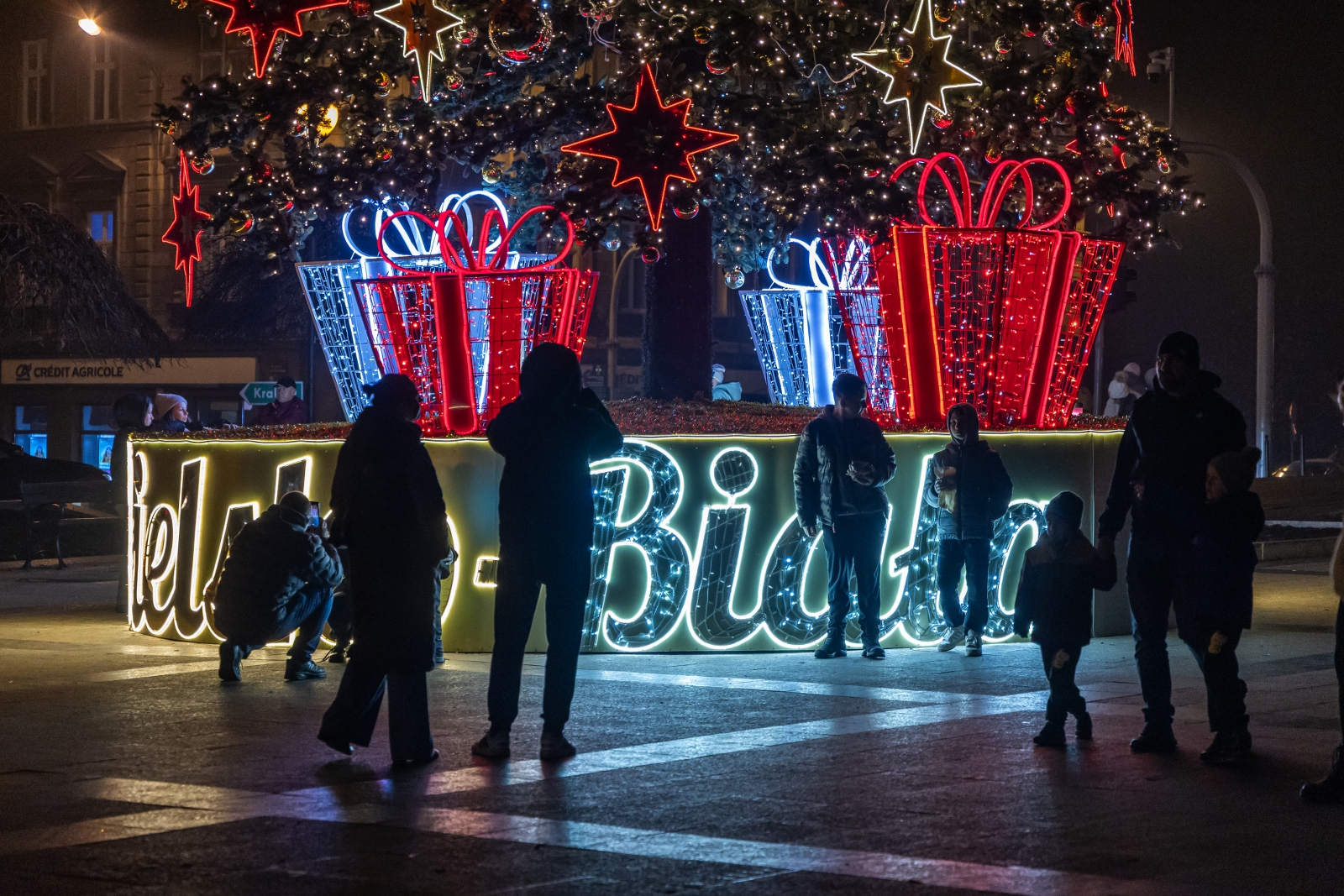 na zdjęciu ozdobione miasto i osoby podczas rozświetlenia