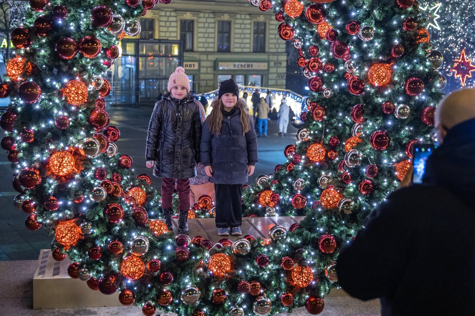 na zdjęciu ozdobione miasto i osoby podczas rozświetlenia
