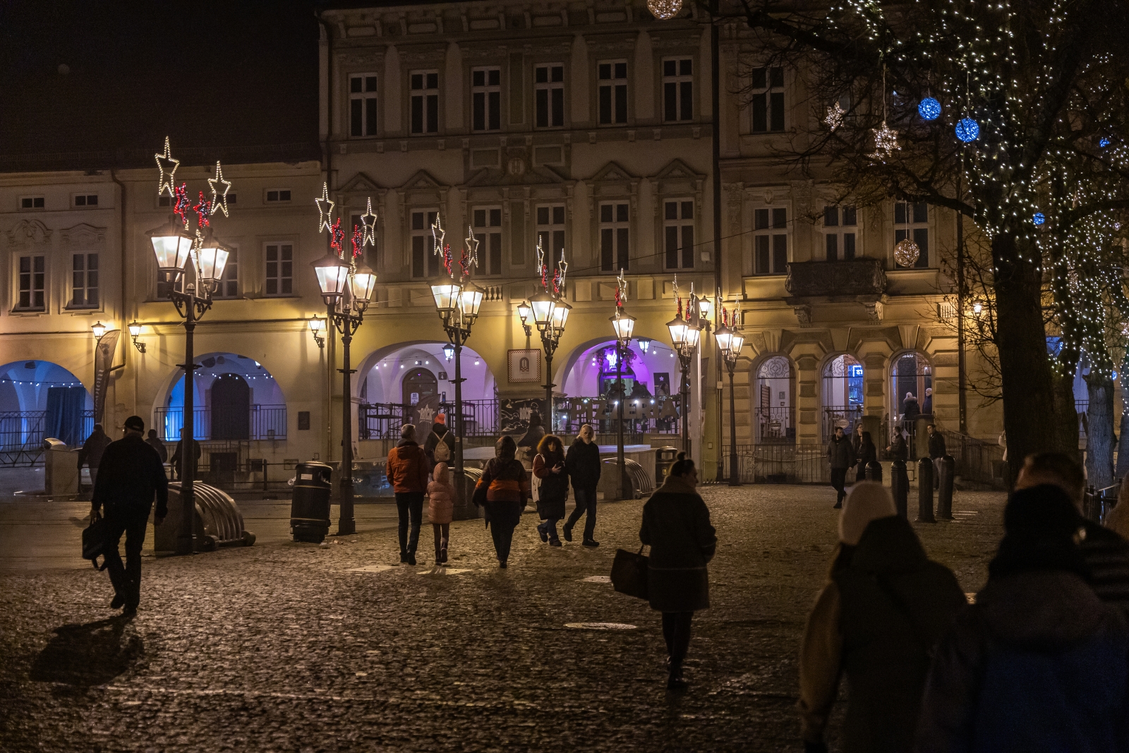 na zdjęciu ozdobione miasto i osoby podczas rozświetlenia