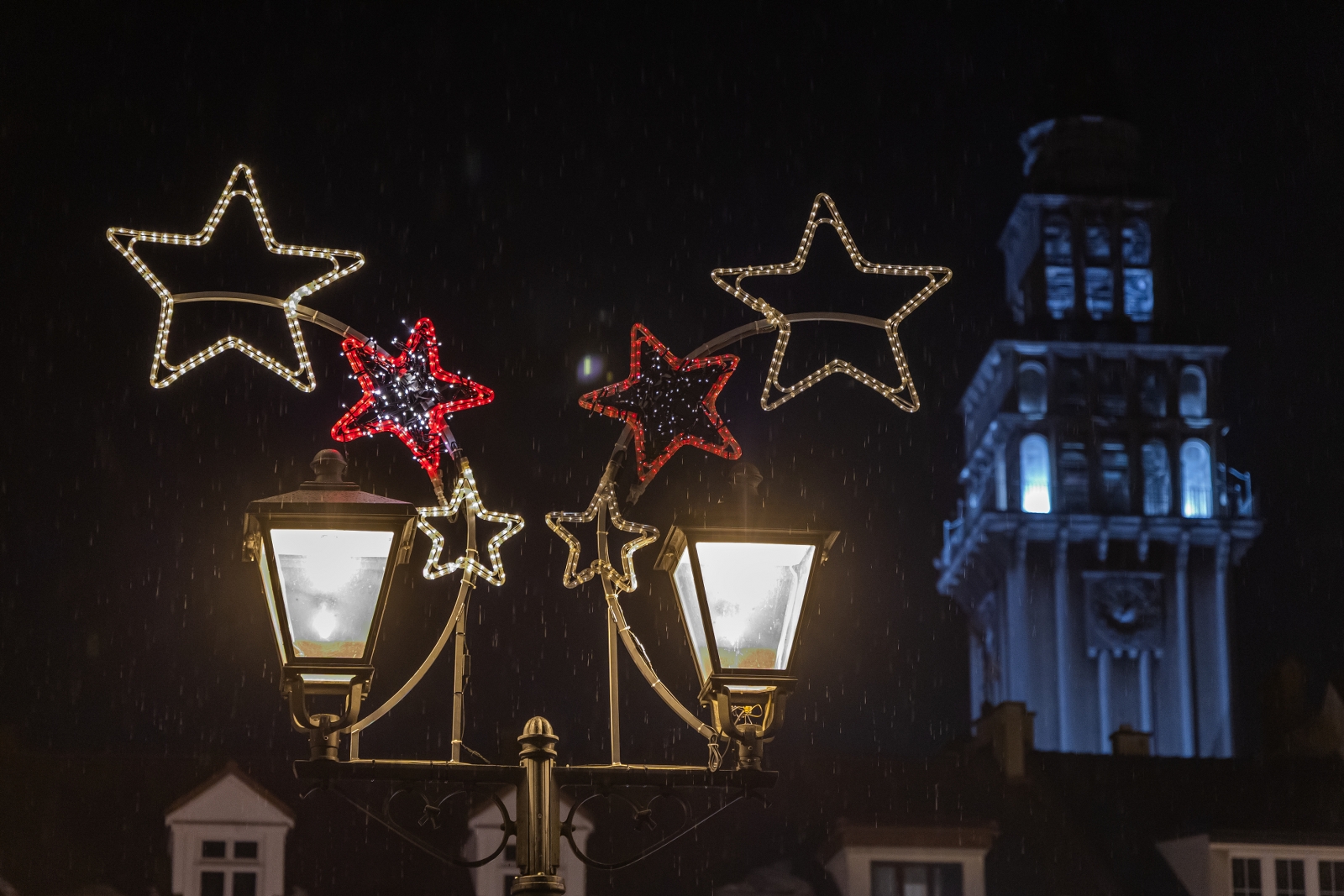 na zdjęciu ozdobione miasto i osoby podczas rozświetlenia