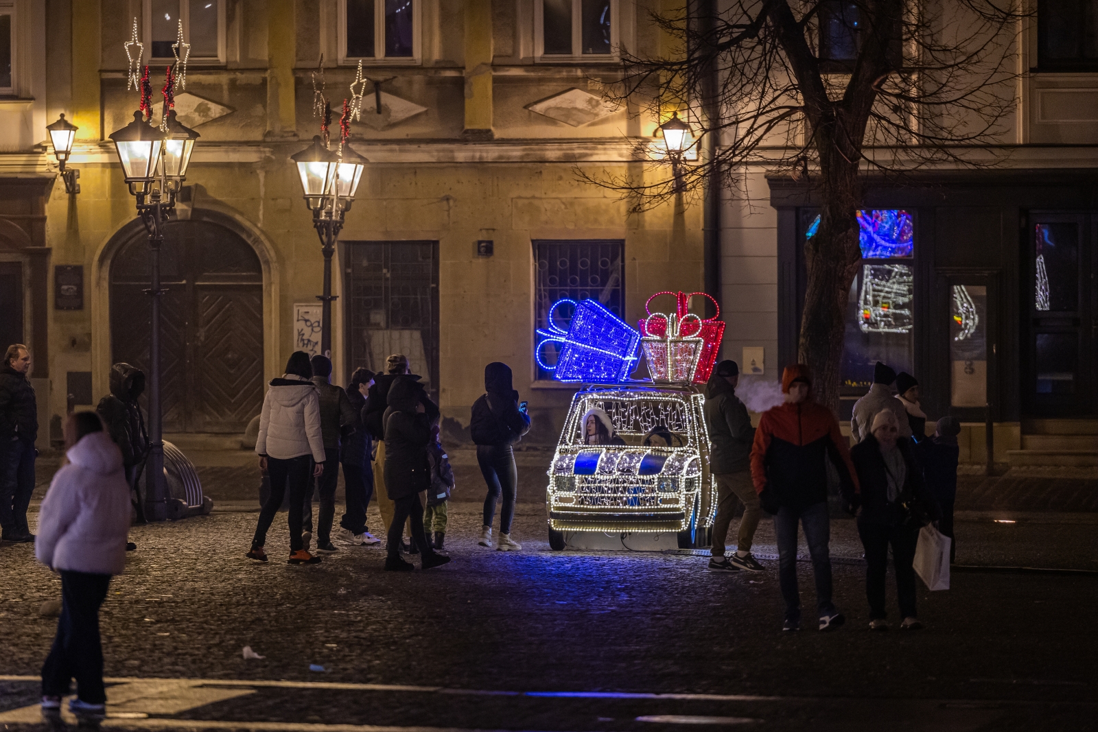 na zdjęciu ozdobione miasto i osoby podczas rozświetlenia