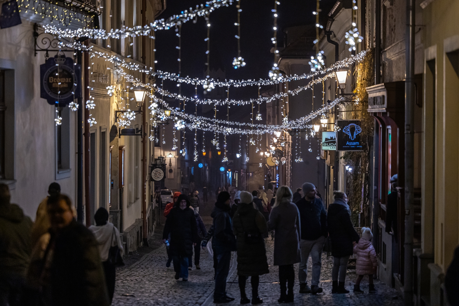 na zdjęciu ozdobione miasto i osoby podczas rozświetlenia