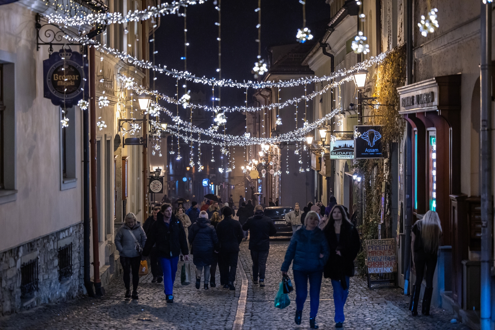 na zdjęciu ozdobione miasto i osoby podczas rozświetlenia