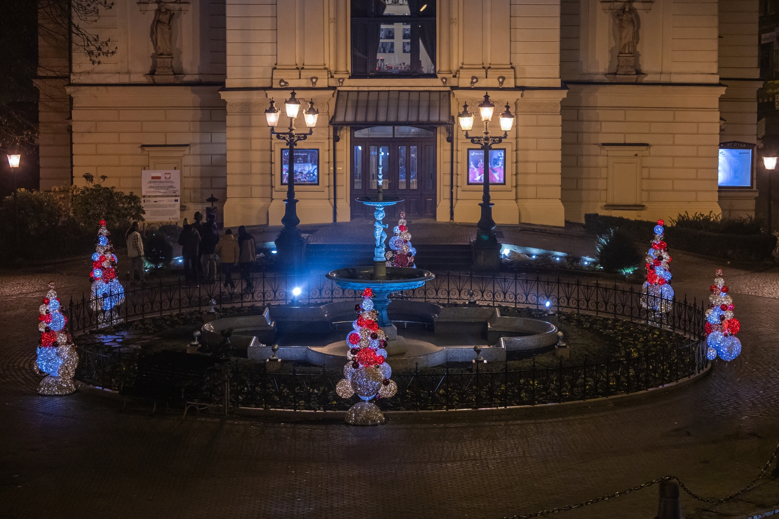 na zdjęciu ozdobione miasto i osoby podczas rozświetlenia