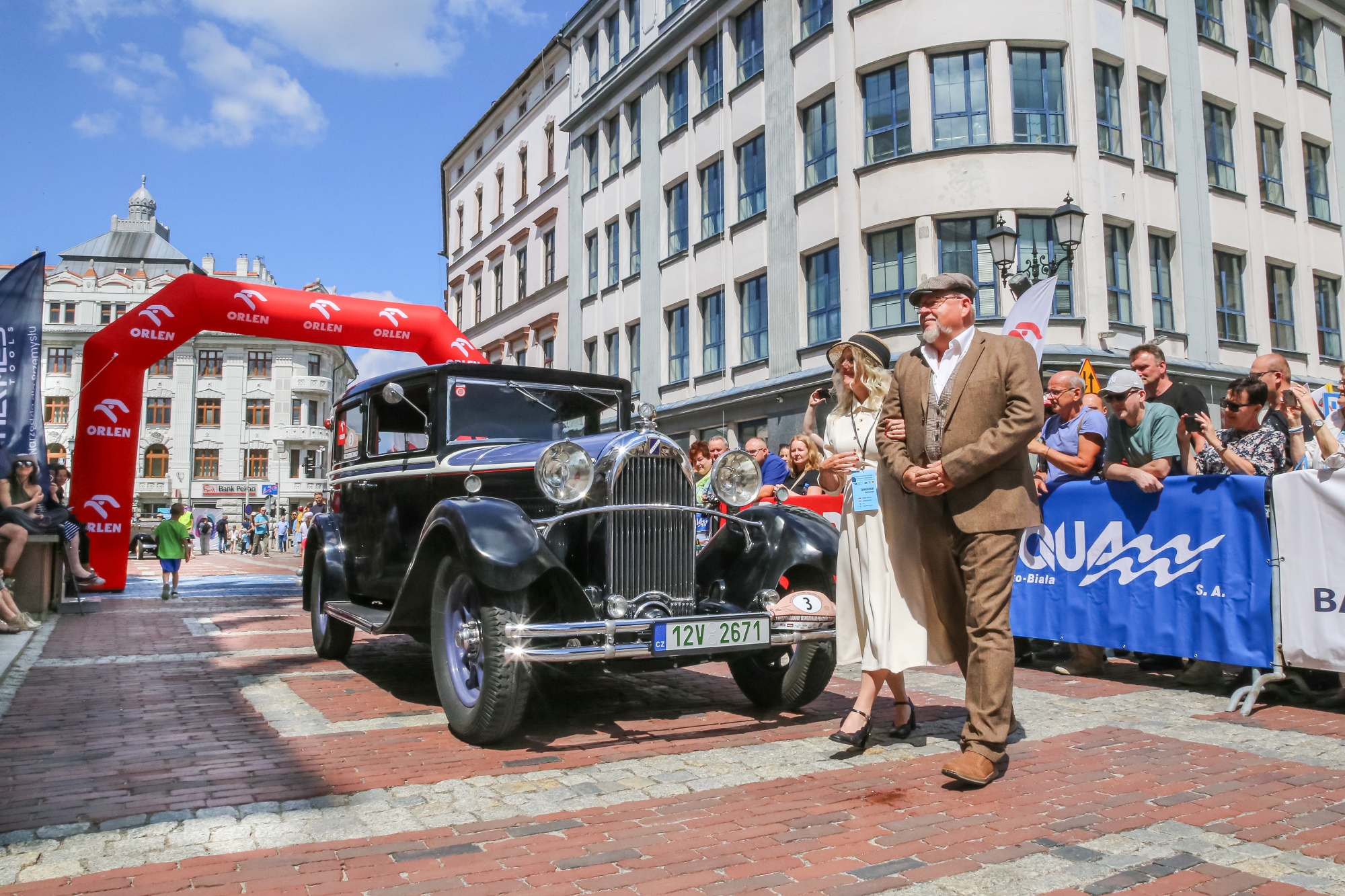 na zdjęciu osoby i samochody podczas konkursu elegancji