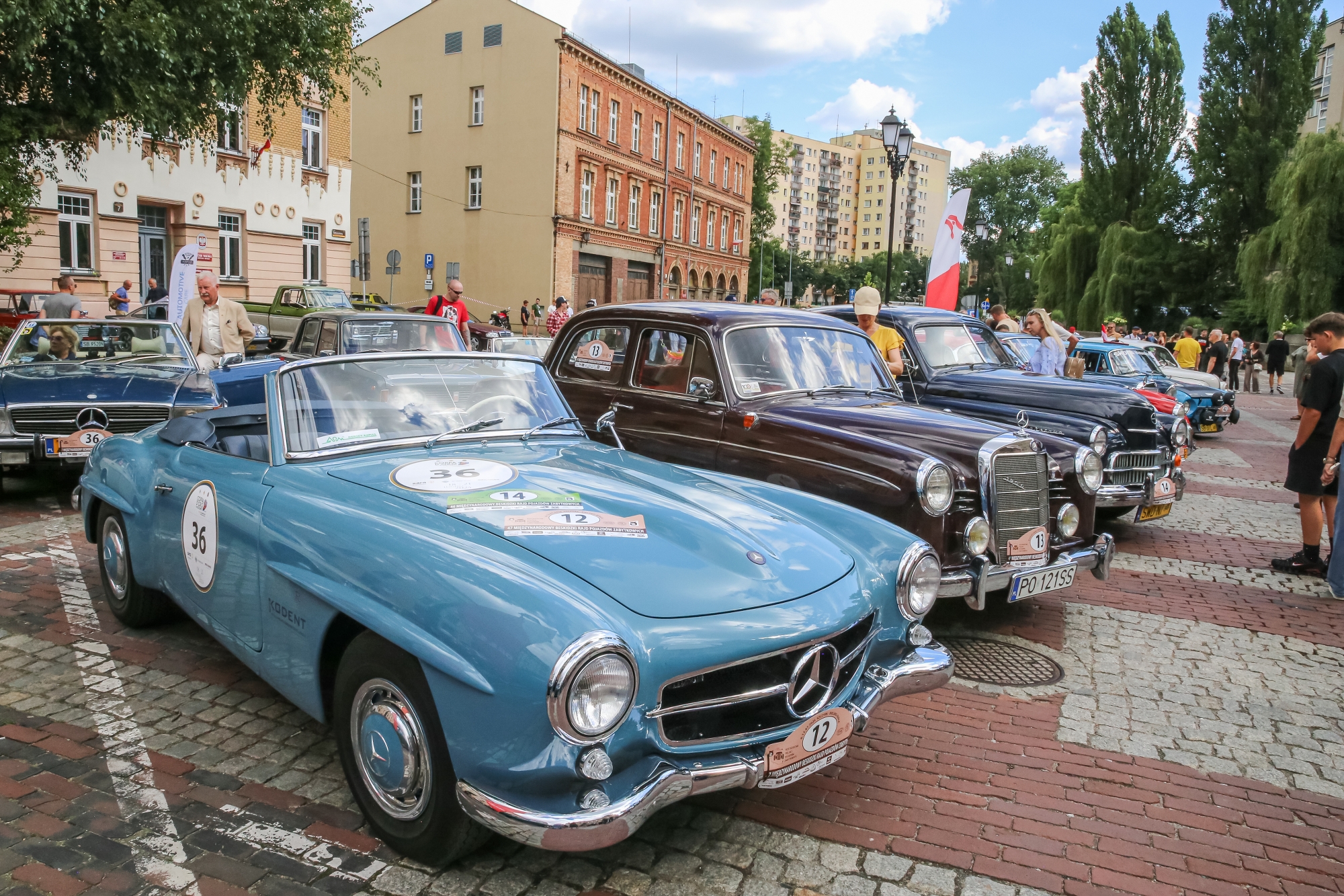 na zdjęciu osoby i samochody podczas konkursu elegancji