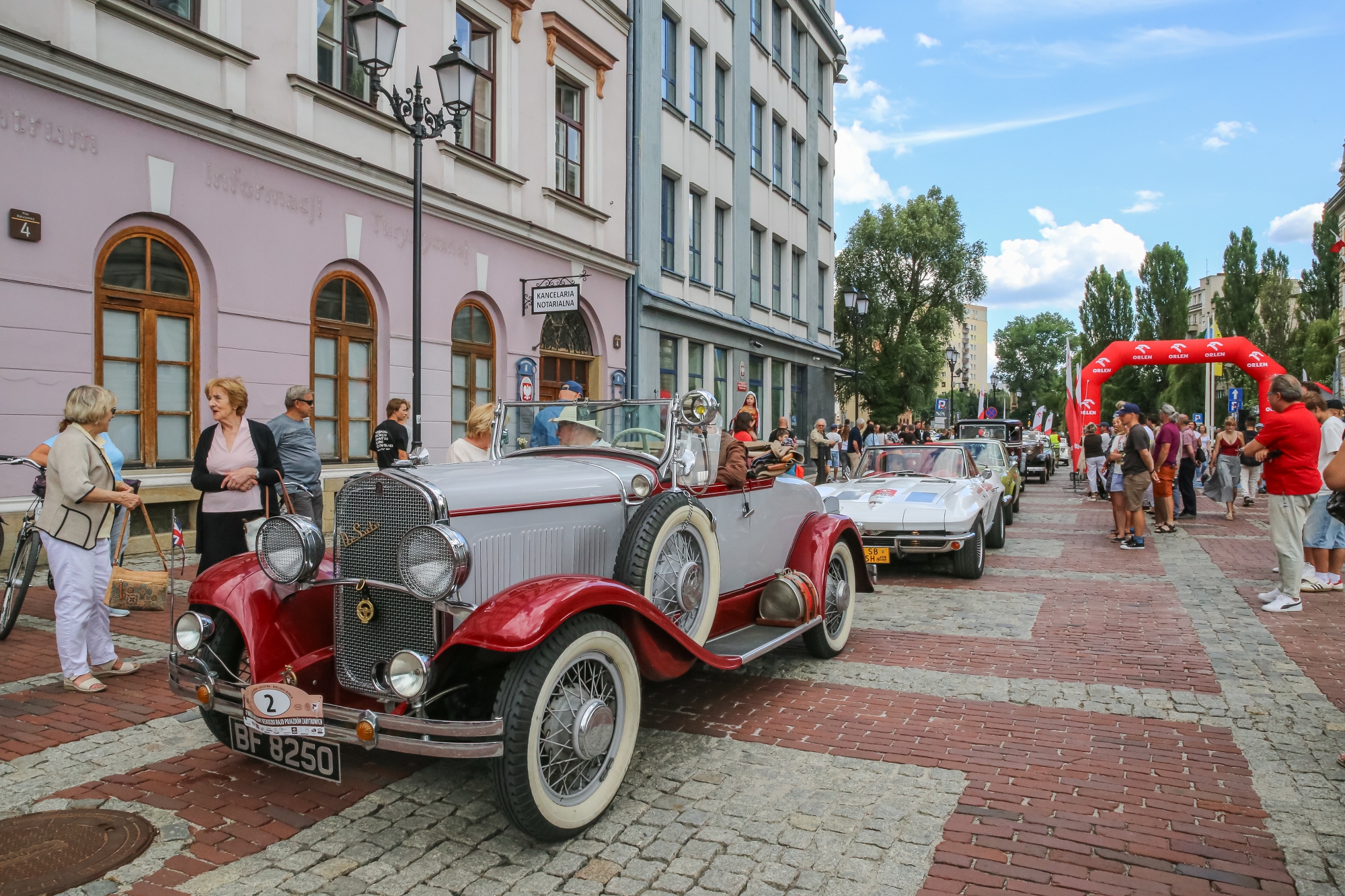 na zdjęciu osoby i samochody podczas konkursu elegancji