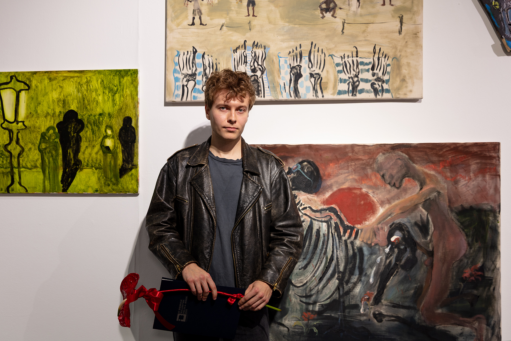 Na zdjęciu artysta przed obrazami