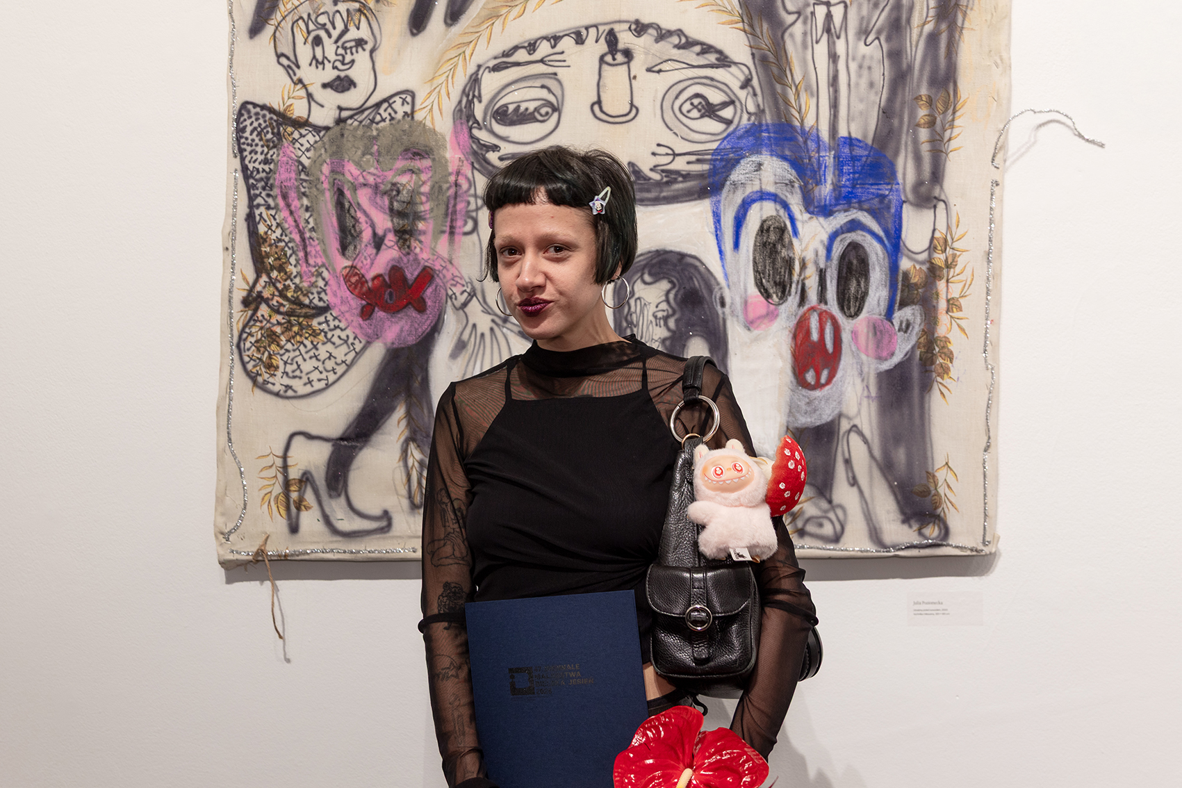 Na zdjęciu osoba nagrodzona przed obrazem