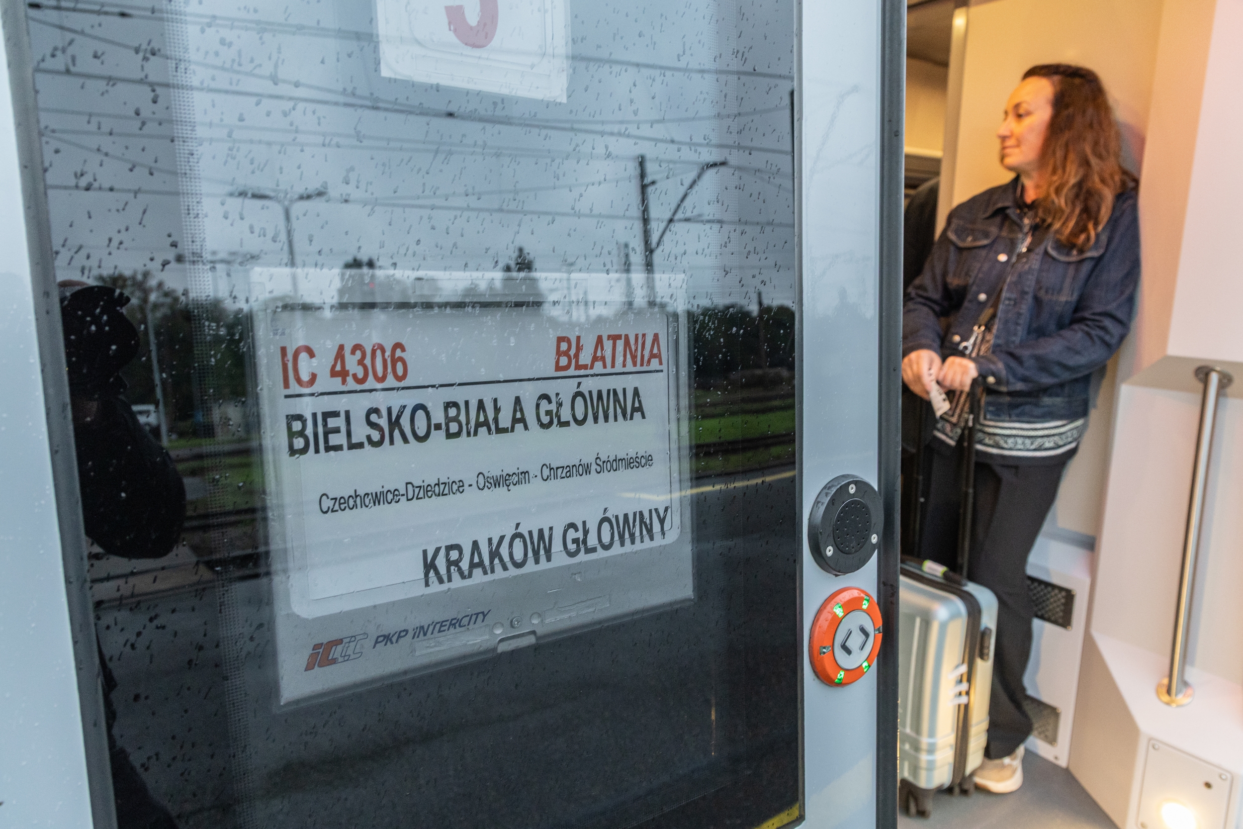 Na zdjęciu stojący ludzie 