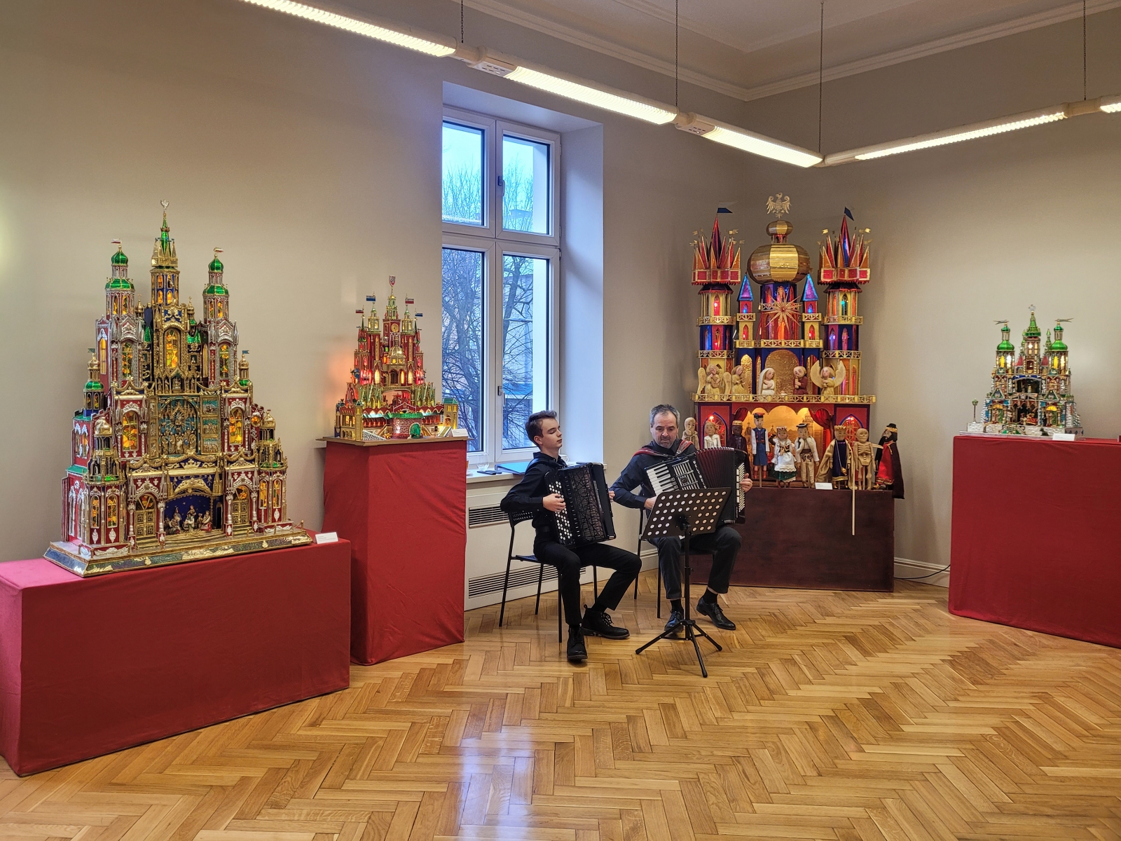 wernisaży wystawy szopek, dwaj muzycy grają na akordeonach