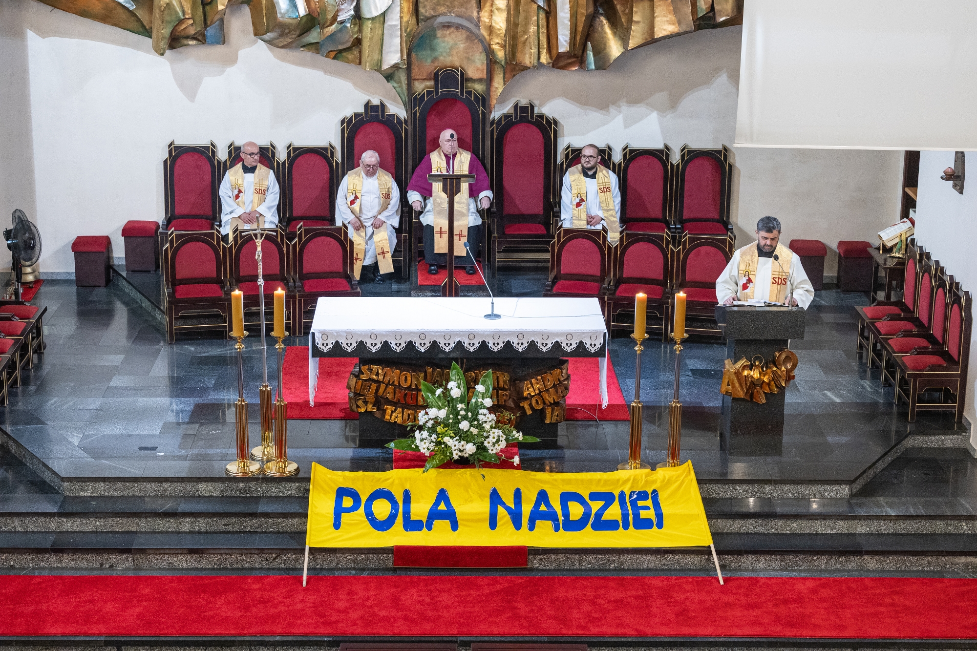 na zdjęciu prezbiterium w kościele i osoby tam siedzące