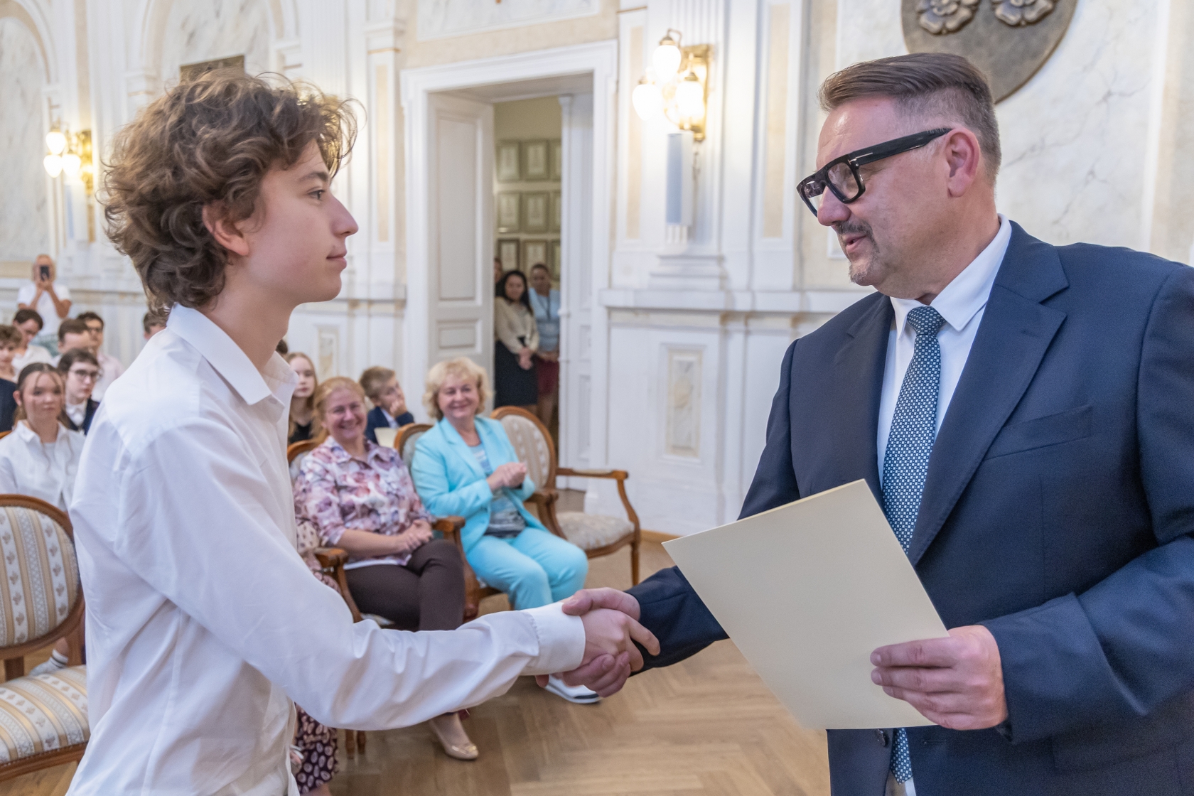 Na zdjęciu prezydent wręcza stypendium