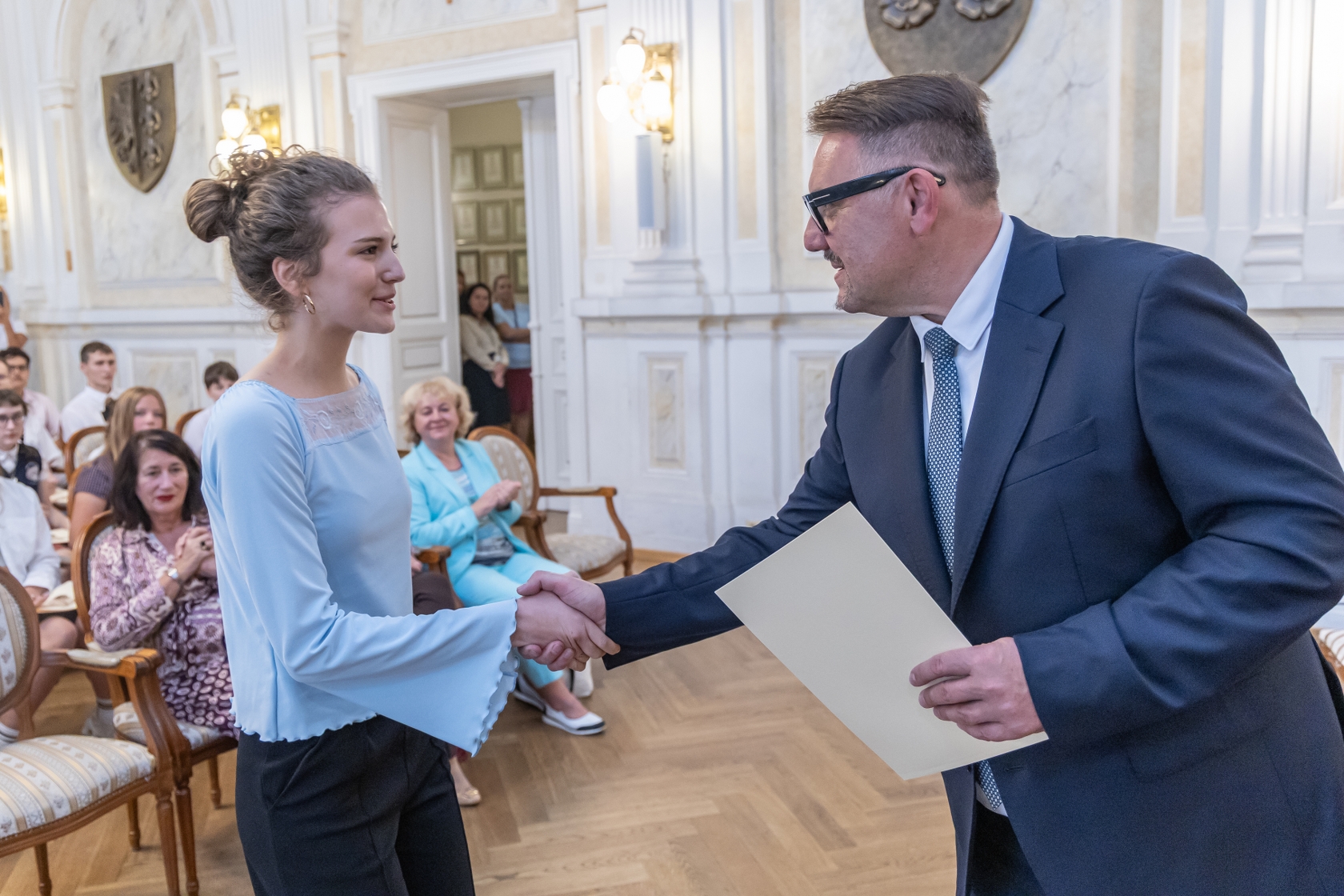 Na zdjęciu prezydent wręcza stypendium