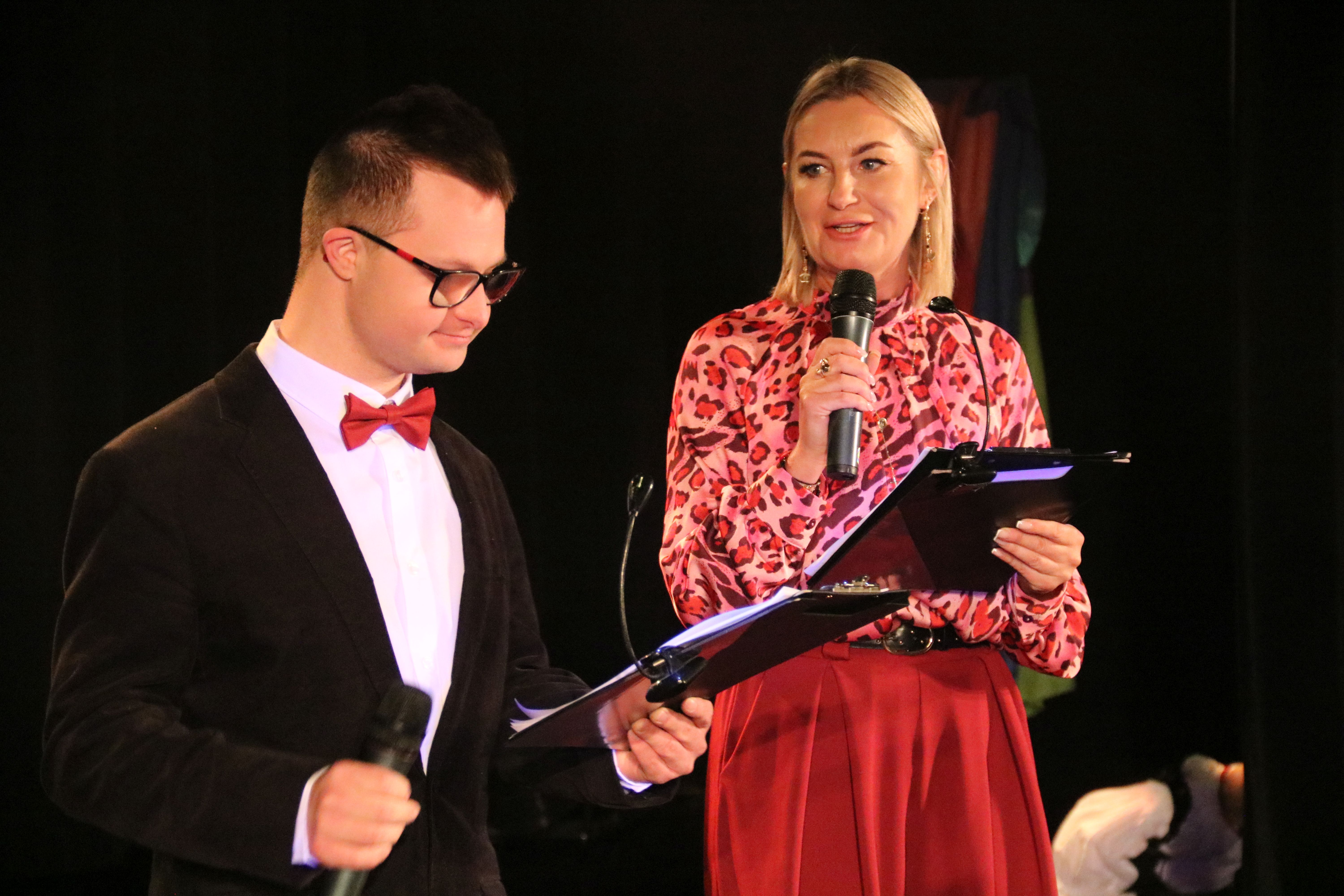 Na zdjęciu stojący ludzie 