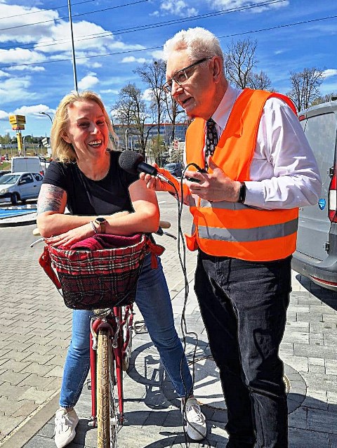 zdjęcie przedstawiające kobietę na rowerze rozmawiającą z mężczyzną na parkingu podczas badania ankietowego