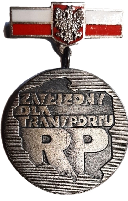 Zdjęcie przedstawiające odznakę „Zasłużony dla transportu Rzeczypospolitej Polskiej”.