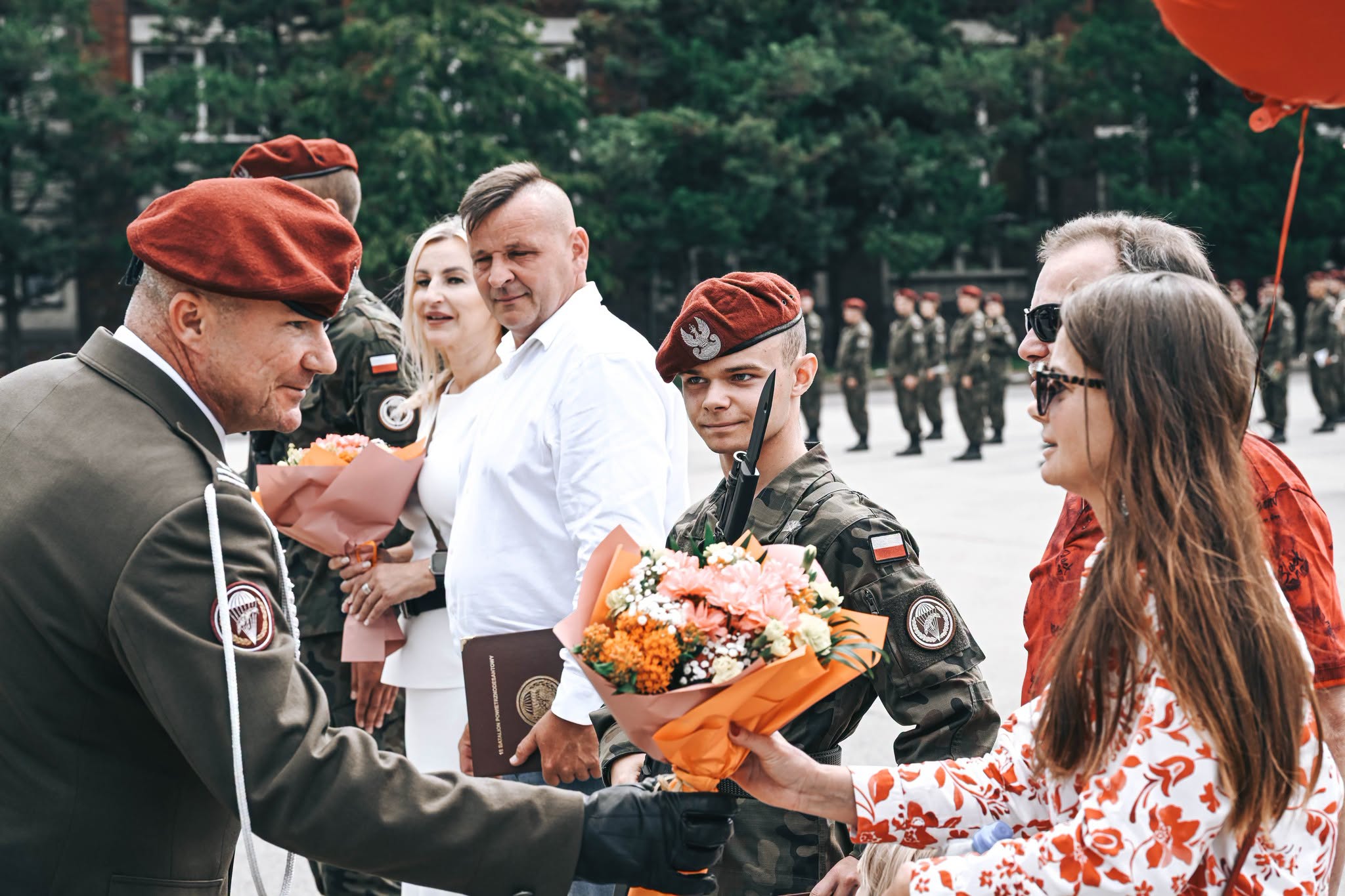 na zdjęciu rodzice żołnierza otrzymują kwiaty