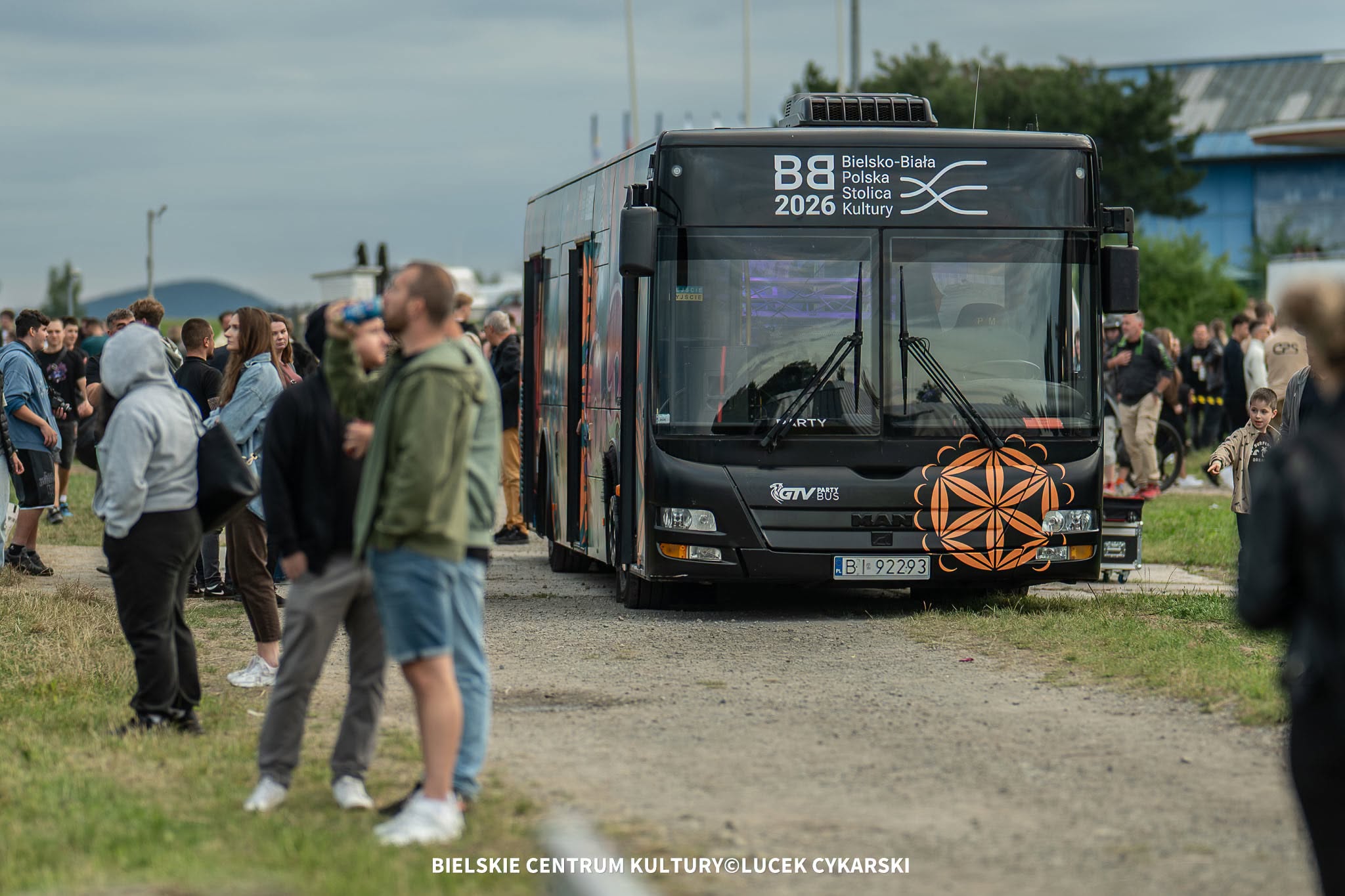 Na zdjęciu autobus i ludzie wokół niego 
