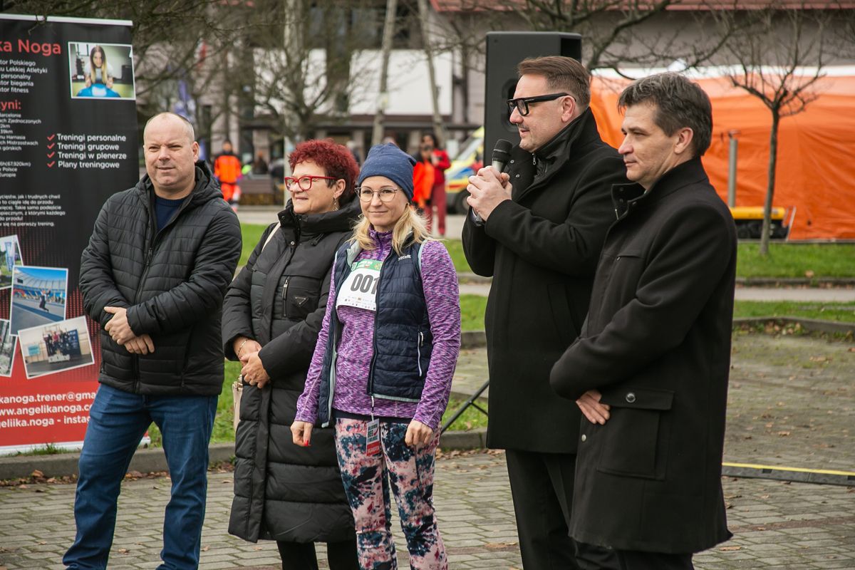 Na zdjęciu stojący ludzie 