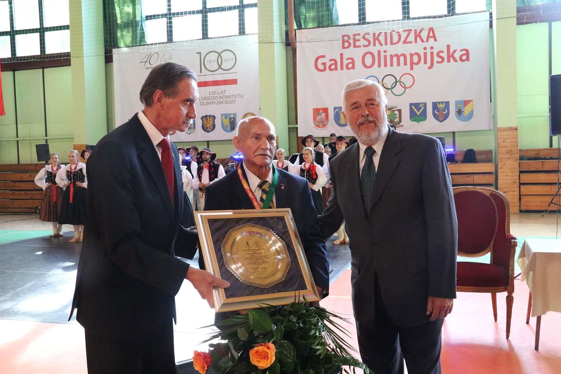 Na zdjęciu stojący ludzie 