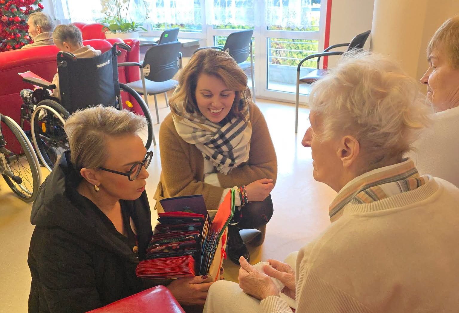 Na zdjęciu ludzie w kartkami świątecznymi 
