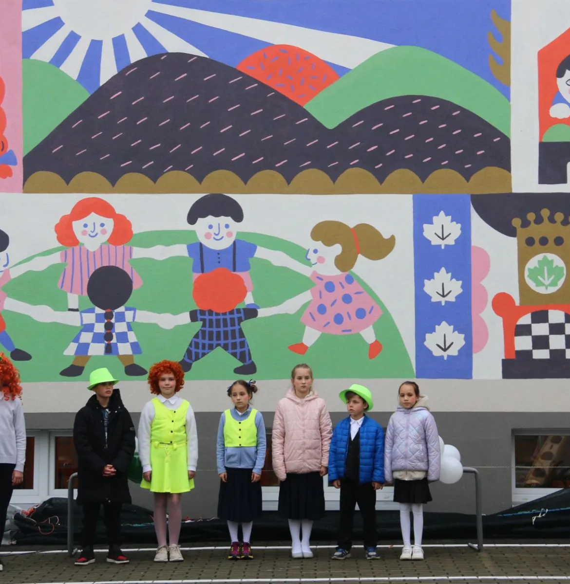 Na zdjęciu stojący ludzie 