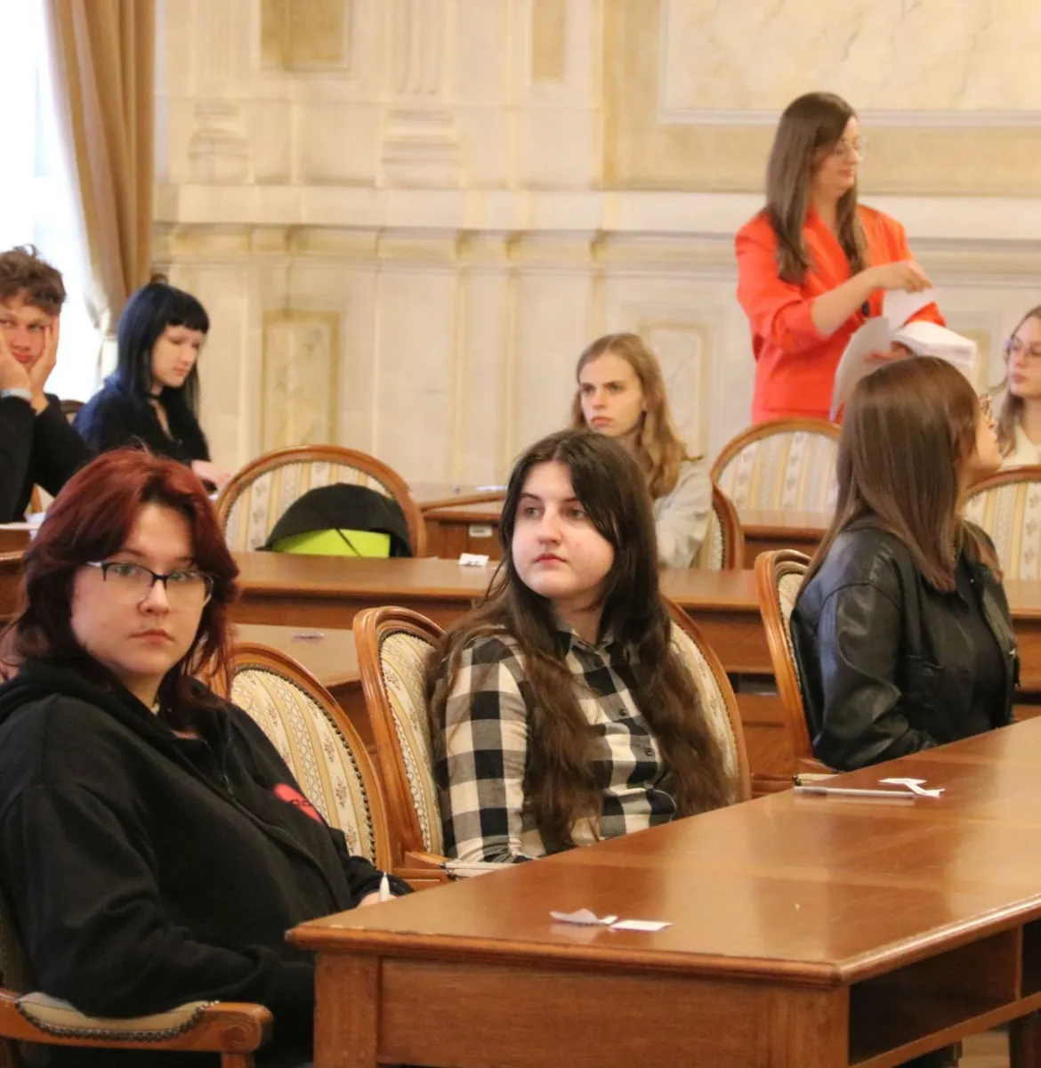 Na zdjęciu siedzący ludzie 