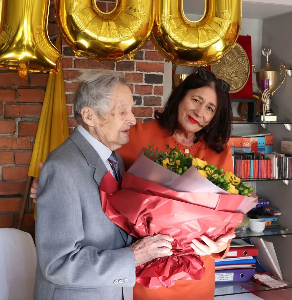 Na zdjęciu stojący ludzie 