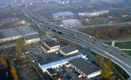 Przebudowa odcinka drogi krajowej nr 52 - na zdjęciu fragment drogi, budynki oraz zieleń