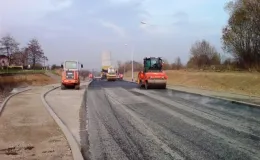 Budowa ul. Sarni Potok w Bielsku-Białej - na zdjęciu budowa drogi, maszyny budowlane oraz zieleń